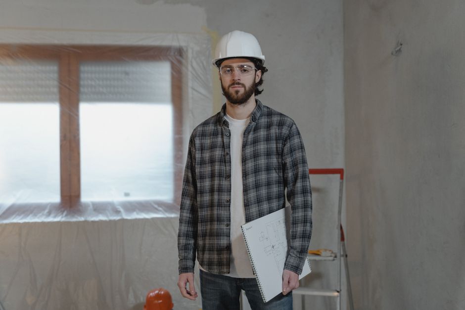 Trabajador de construcción levantando muros de una casa en terreno propio