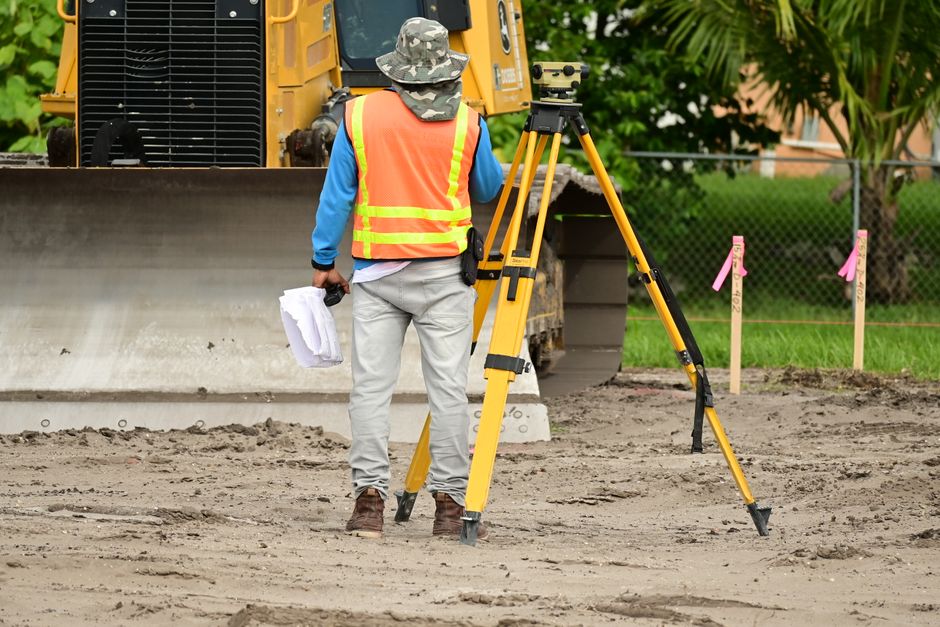 Topógrafo midiendo los límites de un terreno durante un deslinde